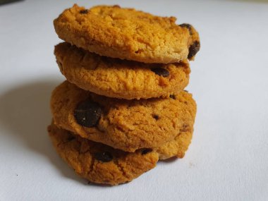 Beyaz arka planda çikolata parçalı çıtır kurabiyeler.