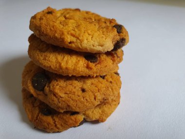 Beyaz arka planda çikolata parçalı çıtır kurabiyeler.