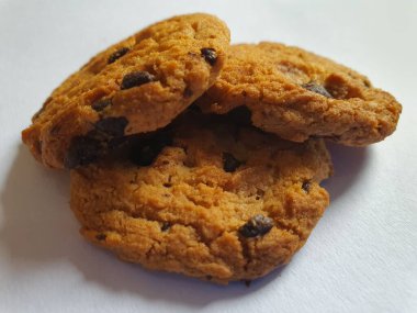 Beyaz arka planda çikolata parçalı çıtır kurabiyeler.