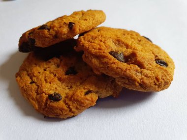 Beyaz arka planda çikolata parçalı çıtır kurabiyeler.