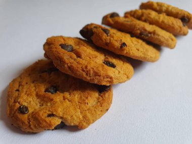 Beyaz arka planda çikolata parçalı çıtır kurabiyeler.