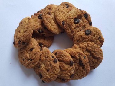 Beyaz arka planda çikolata parçalı çıtır kurabiyeler.