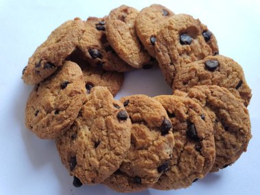 Beyaz arka planda çikolata parçalı çıtır kurabiyeler.