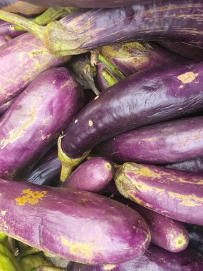 Çeşitli meyve ve sebzelerin fotoğrafları geleneksel pazarda yığılmıştır. Arka plan fotoğrafı için patlıcan meyvelerini kapat.