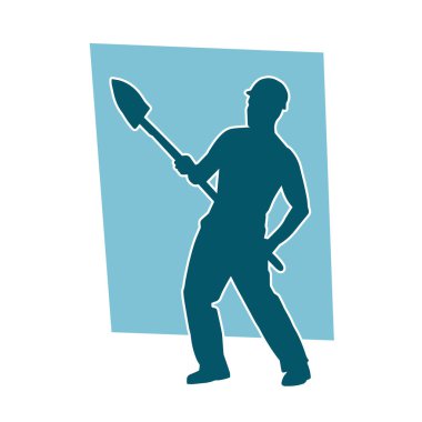 Kürek taşıyan bir işçinin silüeti. Bir işçinin hareket halindeki silueti kürek aracı kullanarak poz verir.