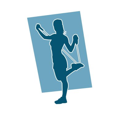 Spor salonundaki siluet kadın halat çekme egzersizi yapıyor. Spor kordonları ip germe direnç eğitimini kaldırır.