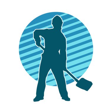 Kürek taşıyan bir işçinin silüeti. Bir işçinin hareket halindeki silueti kürek aracı kullanarak poz verir.