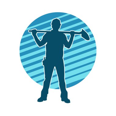 Kürek taşıyan bir işçinin silüeti. Bir işçinin hareket halindeki silueti kürek aracı kullanarak poz verir.