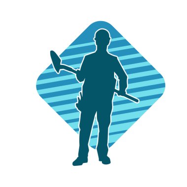 Kürek taşıyan bir işçinin silüeti. Bir işçinin hareket halindeki silueti kürek aracı kullanarak poz verir.