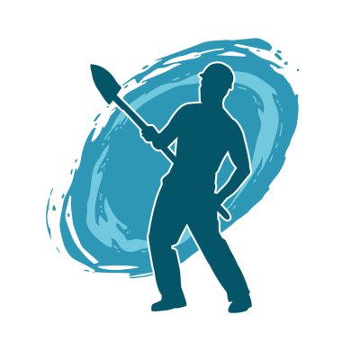 Kürek taşıyan bir işçinin silüeti. Bir işçinin hareket halindeki silueti kürek aracı kullanarak poz verir.