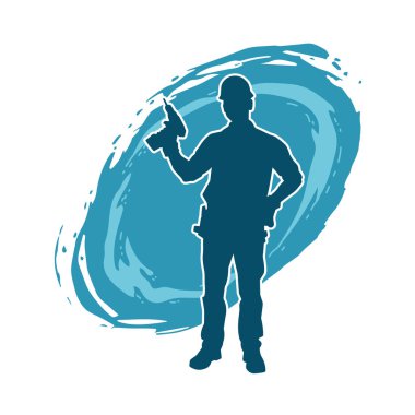 Matkap aletleri taşıyan inşaat işçisi kostümlü bir adamın silueti. İnşaat işçisi erkek silueti elektrikli matkapla hareket halinde poz veriyor. 