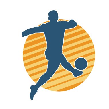 Top tekmeleyen bir erkek futbolcunun silueti. Hareket halindeki bir futbolcunun silueti.