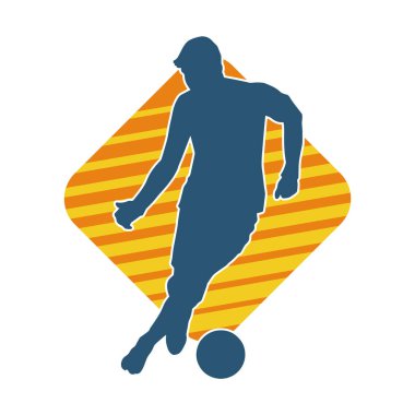 Top tekmeleyen bir erkek futbolcunun silueti. Hareket halindeki bir futbolcunun silueti.