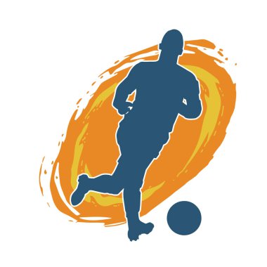 Top tekmeleyen bir erkek futbolcunun silueti. Hareket halindeki bir futbolcunun silueti.
