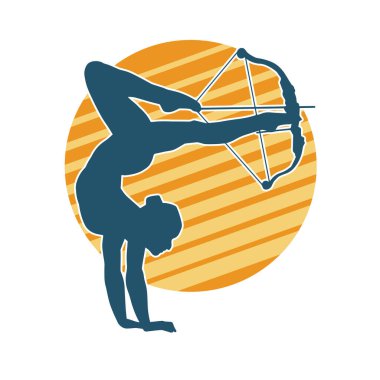 Kadın okçunun silueti akrobatik poz vermeyi hedefliyor. Okçuluk akrobasisi pozu veren bir kadının silueti.. 