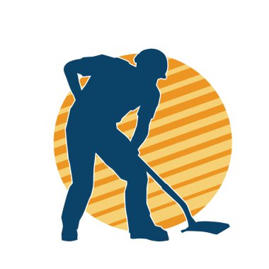 Kürek taşıyan bir işçinin silüeti. Bir işçinin hareket halindeki silueti kürek aracı kullanarak poz verir.