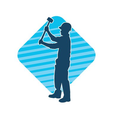 Çalışan bir işçinin silueti balyoz aletini kullanarak hareket halinde poz verir.