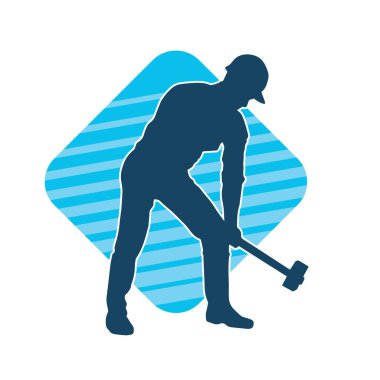 Çalışan bir işçinin silueti balyoz aletini kullanarak hareket halinde poz verir.