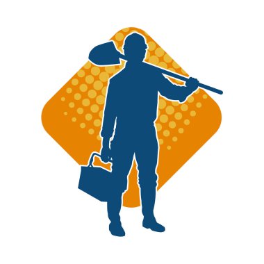 Kürek taşıyan bir işçinin silüeti. Bir işçinin hareket halindeki silueti kürek aracı kullanarak poz verir.