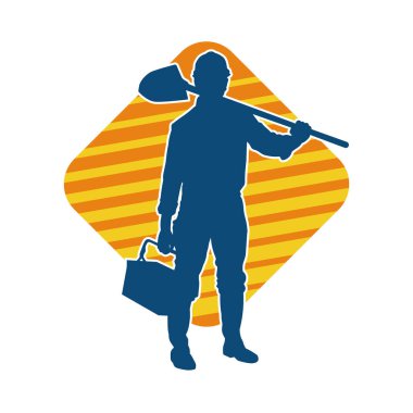 Kürek taşıyan bir işçinin silüeti. Bir işçinin hareket halindeki silueti kürek aracı kullanarak poz verir.