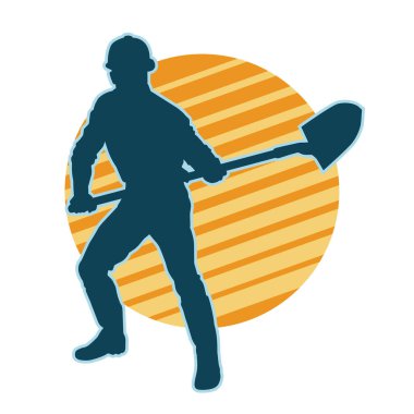 Kürek taşıyan bir işçinin silüeti. Bir işçinin hareket halindeki silueti kürek aracı kullanarak poz verir.