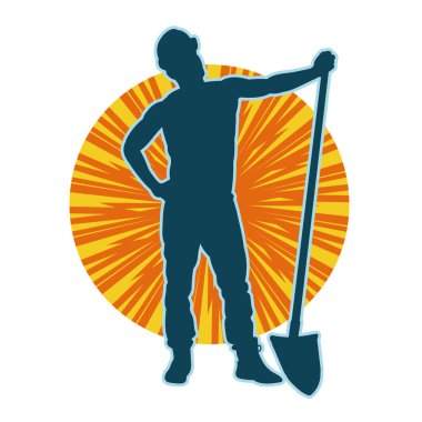 Kürek taşıyan bir işçinin silüeti. Bir işçinin hareket halindeki silueti kürek aracı kullanarak poz verir.