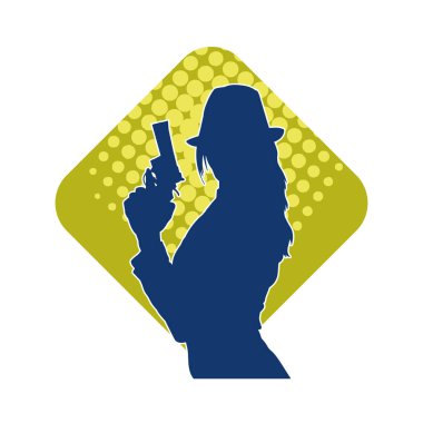 Uzun pantolon ve fötr şapka giyen zayıf bir kadın modelin silueti. Tabancayla poz veriyor..