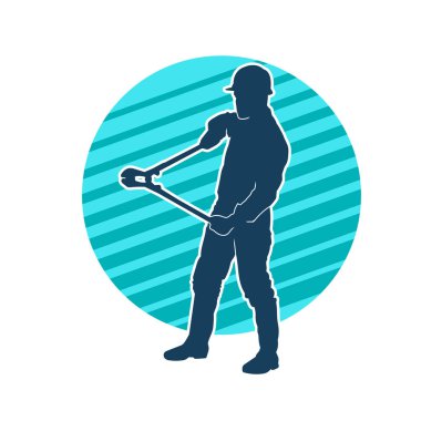 Bir erkek işçinin silueti hareket halindeyken büyük bir kerpeten ya da cıvata kesici aletle poz verir