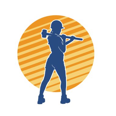 Açık havada çalışan bir modelin silueti balyoz teçhizatıyla poz veriyor.