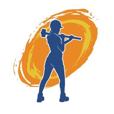 Açık havada çalışan bir modelin silueti balyoz teçhizatıyla poz veriyor.