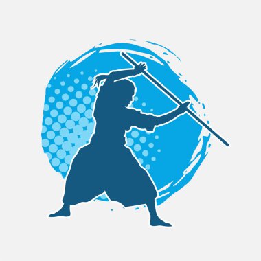 Erkek dövüş sanatları ustasının silueti hareket halindeyken toya ya da şaft silahı kullanarak poz verir.