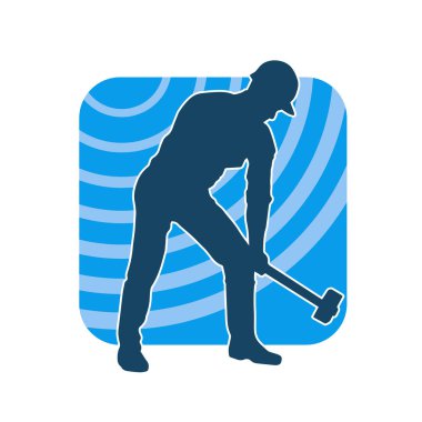 Çalışan bir işçinin silueti balyoz aletini kullanarak hareket halinde poz verir.