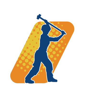 Çalışan bir işçinin silueti balyoz aletini kullanarak hareket halinde poz verir.