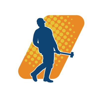 Çalışan bir işçinin silueti balyoz aletini kullanarak hareket halinde poz verir.