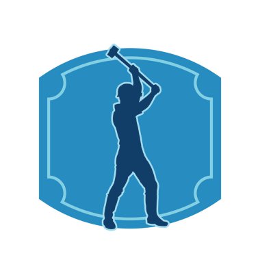 Çalışan bir işçinin silueti balyoz aletini kullanarak hareket halinde poz verir.