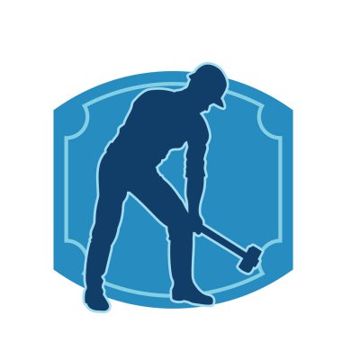 Çalışan bir işçinin silueti balyoz aletini kullanarak hareket halinde poz verir.