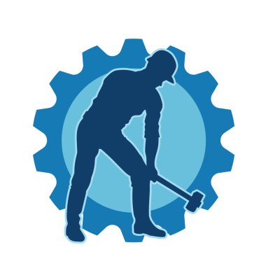 Çalışan bir işçinin silueti balyoz aletini kullanarak hareket halinde poz verir.