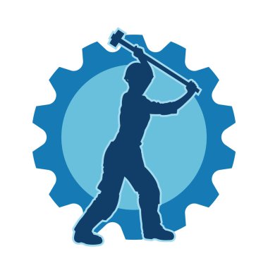 Çalışan bir işçinin silueti balyoz aletini kullanarak hareket halinde poz verir.