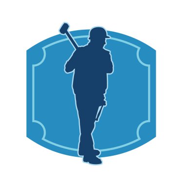 Çalışan bir işçinin silueti balyoz aletini kullanarak hareket halinde poz verir.