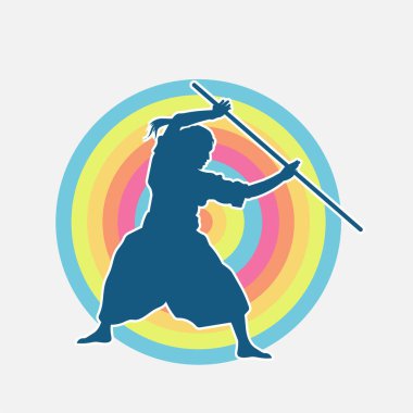 Erkek dövüş sanatları ustasının silueti hareket halindeyken toya ya da şaft silahı kullanarak poz verir.