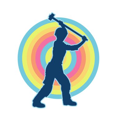 Çalışan bir işçinin silueti balyoz aletini kullanarak hareket halinde poz verir.