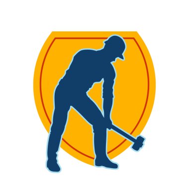 Çalışan bir işçinin silueti balyoz aletini kullanarak hareket halinde poz verir.