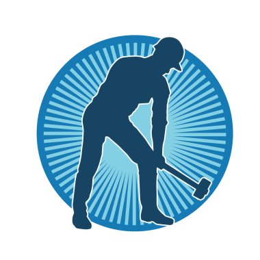 Çalışan bir işçinin silueti balyoz aletini kullanarak hareket halinde poz verir.