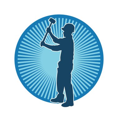 Çalışan bir işçinin silueti balyoz aletini kullanarak hareket halinde poz verir.