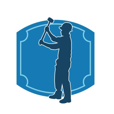 Çalışan bir işçinin silueti balyoz aletini kullanarak hareket halinde poz verir.