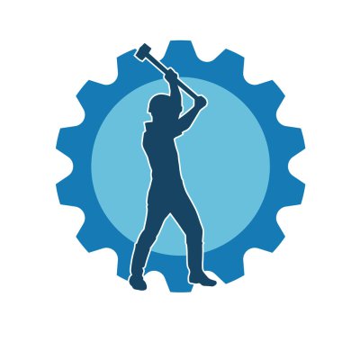 Çalışan bir işçinin silueti balyoz aletini kullanarak hareket halinde poz verir.