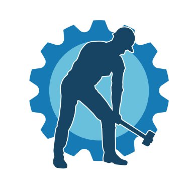 Çalışan bir işçinin silueti balyoz aletini kullanarak hareket halinde poz verir.