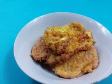 Mavi arka planda beyaz bir kaseye konmuş sahanda yumurta.