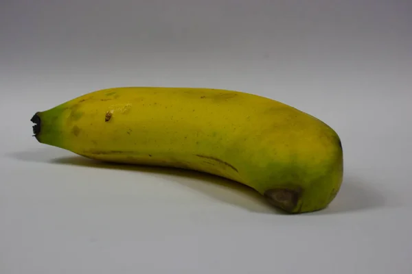灰色の背景に黄色のバナナの実 — ストック写真