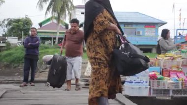 Batı Kutai, Doğu Kalimantan, Endonezya - 21 Ekim 2022 - seyahat etmek isteyen insanlar çantalarını bir teknede taşırlar.